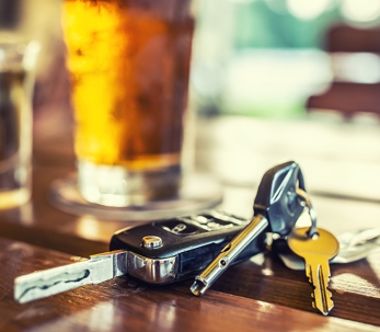 Car keys next to a glass of liquor